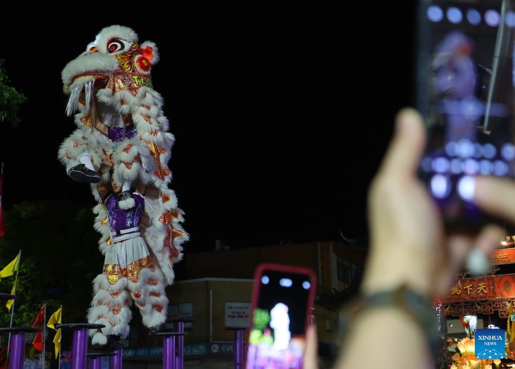 People take photos of a lion dance performance during the Cabramatta Moon Festival in Cabramatta, 26 km west of central Sydney, Australia, Sept. 20, 2026. (Xinhua/Gong Bing)