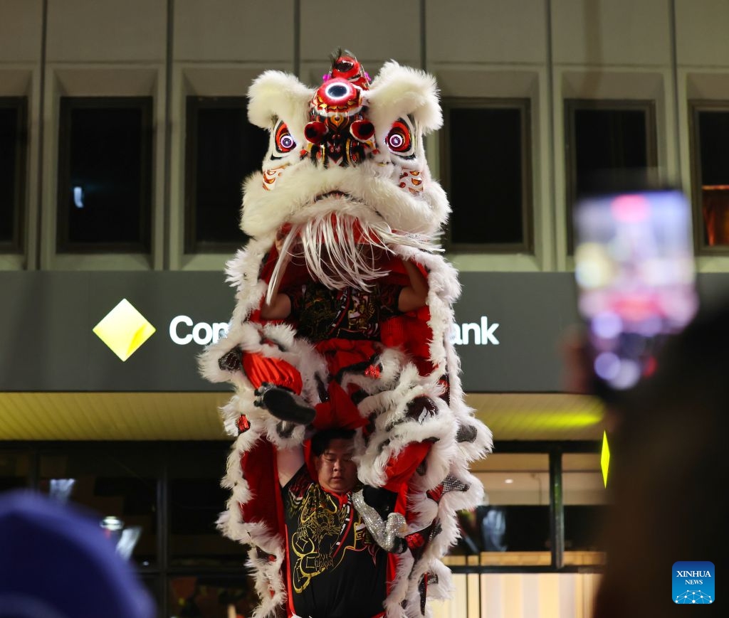 People take photos of a lion dance performance during the Cabramatta Moon Festival in Cabramatta, 26 km west of central Sydney, Australia, Sept. 20, 2026. (Xinhua/Gong Bing)
