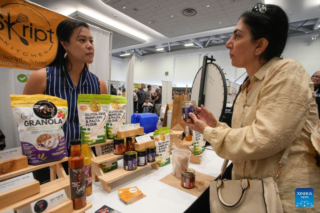A visitor looks at gluten-free food products at the Gluten Free Expo in Vancouver, British Columbia, Canada, Sept. 20, 2026. The event featured gluten-free food and beverage products, sampling, shopping and educational presentations. (Photo by Liang Sen/Xinhua)