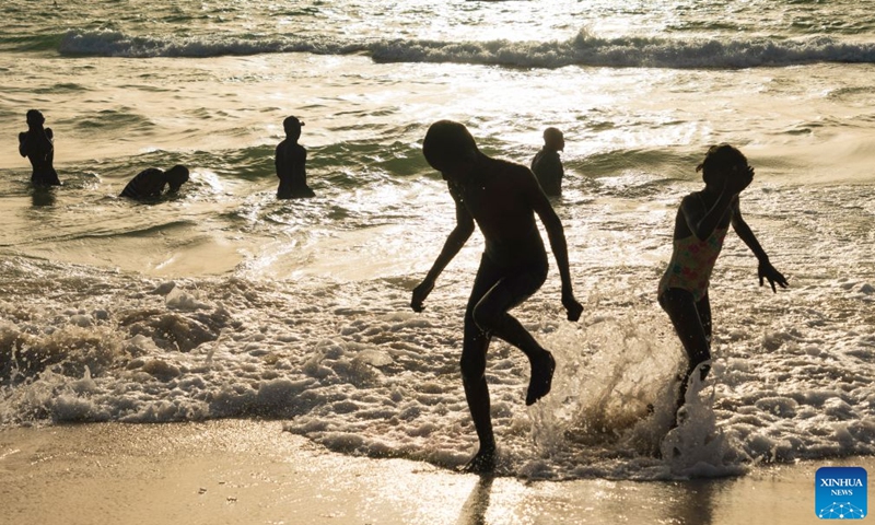 People enjoy leisure time in the sea at the Nouakchott Fishing Port in Nouakchott, Mauritania, Sept. 20, 2026. The Nouakchott Fishing Port, located on the Atlantic coast, is an important fishing hub in Mauritania. The port is known for its rows of traditional wooden pirogues and is a popular gathering place for local residents. (Xinhua/Xie Jianfei)