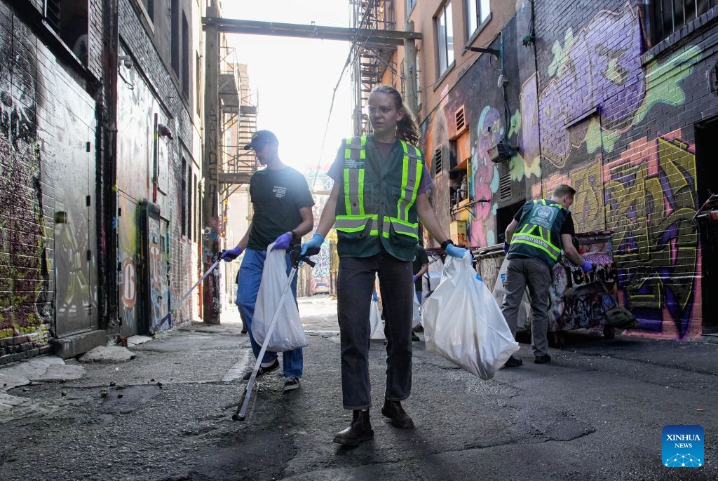 Volunteers collect garbage from a street to mark World Cleanup Day in Vancouver, British Columbia, Canada, Sept. 20, 2026. Volunteers teamed up to clean up streets in downtown Vancouver on Sunday to mark World Cleanup Day, a global environmental event observed annually on Sept. 20. (Photo by Liang Sen/Xinhua)