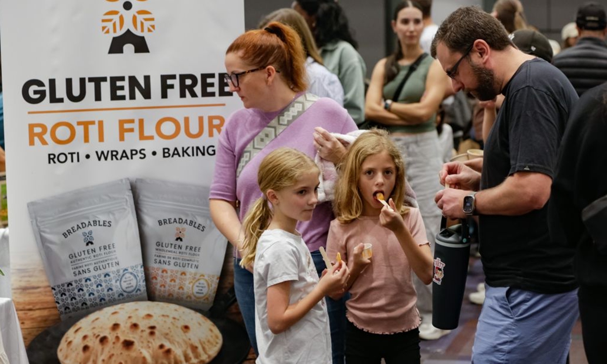 Visitors taste gluten free food products at the Gluten Free Expo in Vancouver, British Columbia, Canada, Sept. 20, 2026. The event featured gluten-free food and beverage products, sampling, shopping and educational presentations. (Photo by Liang Sen/Xinhua)