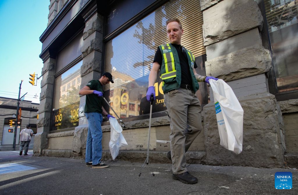 Volunteers collect garbage from a street to mark World Cleanup Day in Vancouver, British Columbia, Canada, Sept. 20, 2026. Volunteers teamed up to clean up streets in downtown Vancouver on Sunday to mark World Cleanup Day, a global environmental event observed annually on Sept. 20. (Photo by Liang Sen/Xinhua)