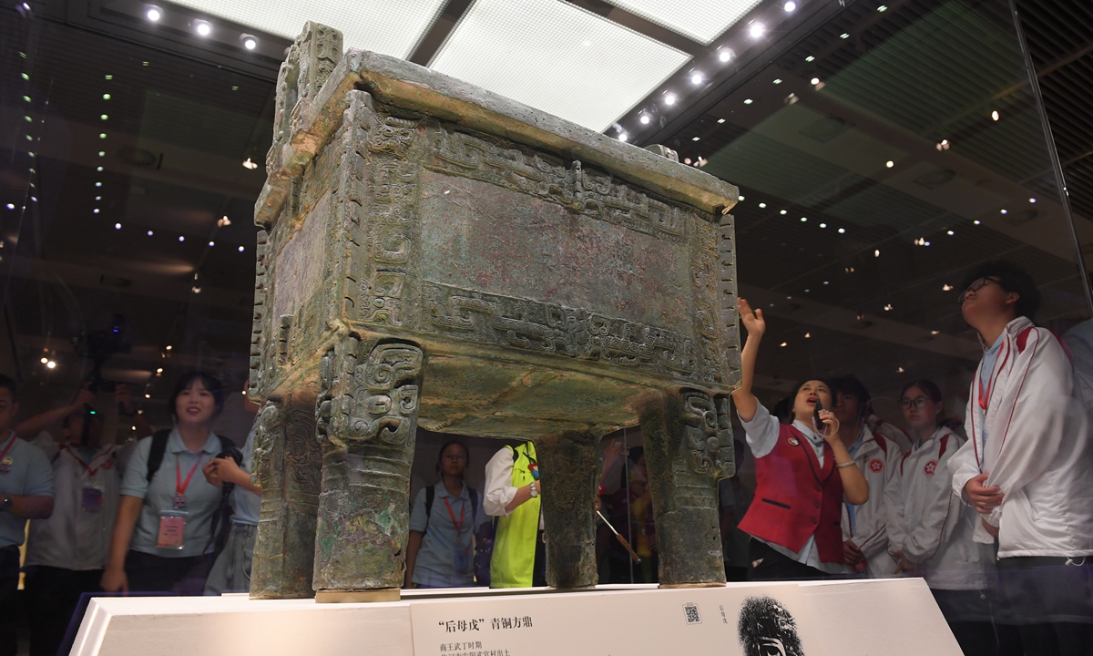 Representatives of the Hong Kong and Macao special administrative regions' youth flag-raising teams visit the National Museum of China in Beijing, where a docent introduces the Houmuwu square cauldron, which is currently the heaviest known bronze ware from ancient China. Representatives of flag-raising teams from primary and secondary schools and universities in Hong Kong and Macao are in Beijing for the themed activity called