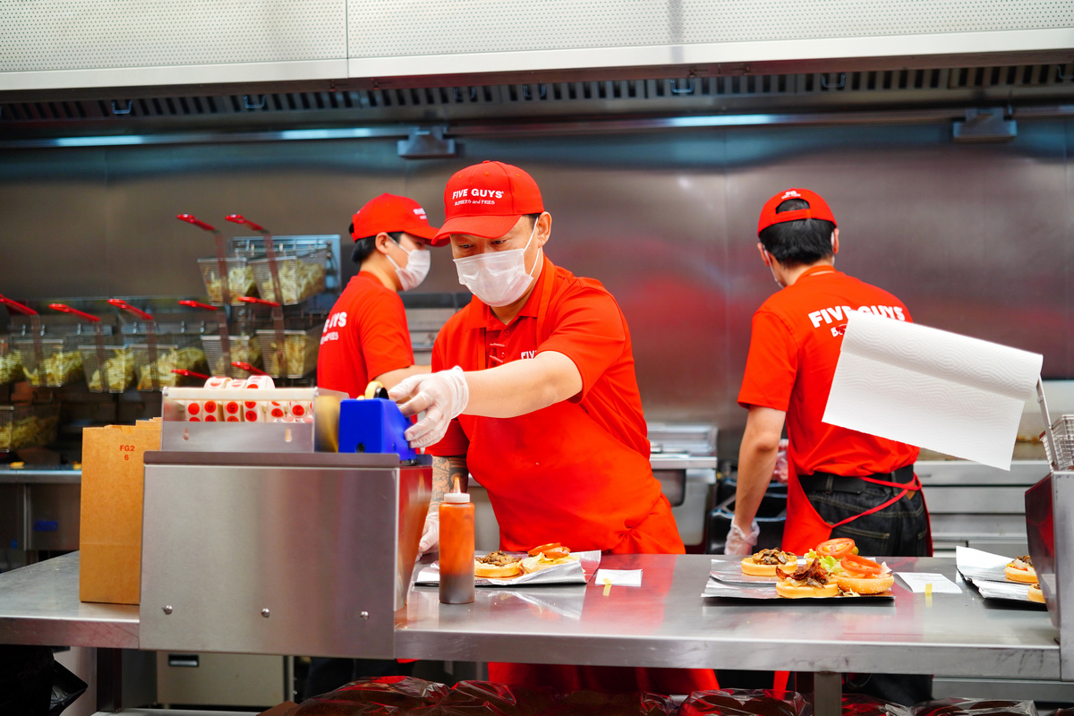 Staff members work at the American burger chain Five Guys in Beijing's Xidan Joy City shopping complex on August 18, 2026. Photo: VCG