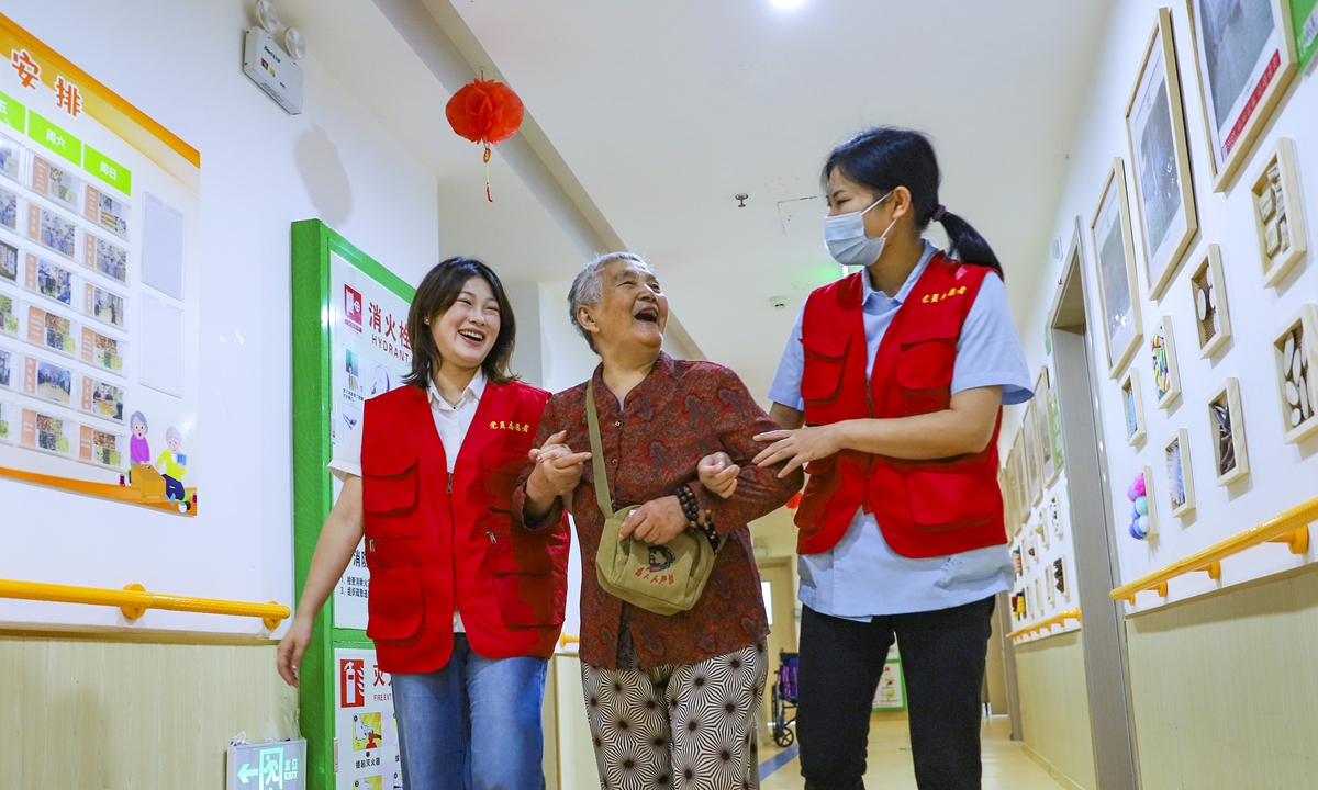 Volunteers and social workers accompany an elderly resident on a walk and chat with her at Zhongwang Elderly Care Service Center in Wuhu, East China's Anhui Province, on September 21, 2026. Photo: VCG