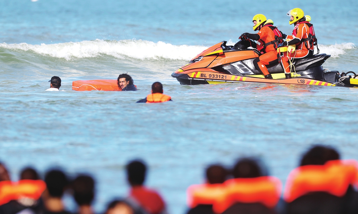 A group of migrants attempting to cross the English Channel in a dinghy are helped by members of a rescue team in Hardelot, France, on September 23, 2026. One person died after one dinghy capsized. Although the number of people crossing the Channel in small boats has declined, anti-immigration sentiment in the UK remains high, per reports. Photo: VCG