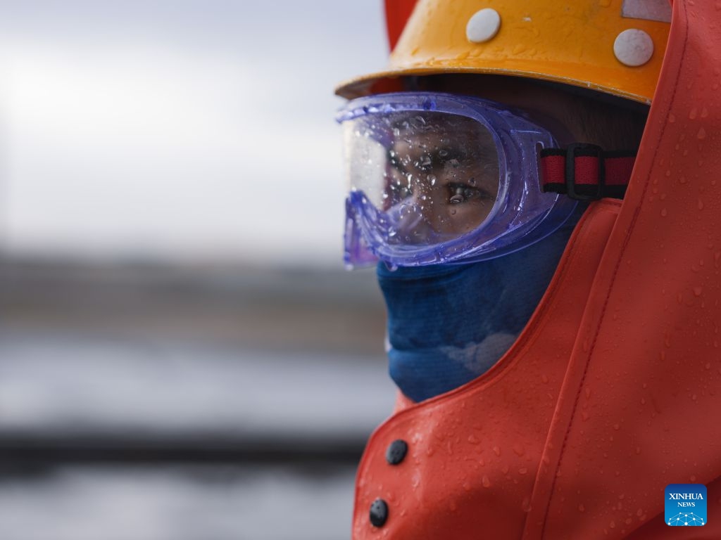A worker carries out cleaning operations on catenary insulators in Haixi Mongolian and Tibetan Autonomous Prefecture, northwest China's Qinghai Province, Sept. 23, 2026. The Qinghai-Xizang Railway crosses Qairhan salt lake in Haixi Mongolian and Tibetan Autonomous Prefecture of northwest China's Qinghai Province. This 33-kilometer section is frequently hit by strong winds carrying salt dust, which accumulates on catenary insulators and can cause power outages. To ensure safe and reliable railway operations, workers use high-pressure washing equipment to remove salt deposits from catenary insulators along the Qairhan section. (Photo: Xinhua)