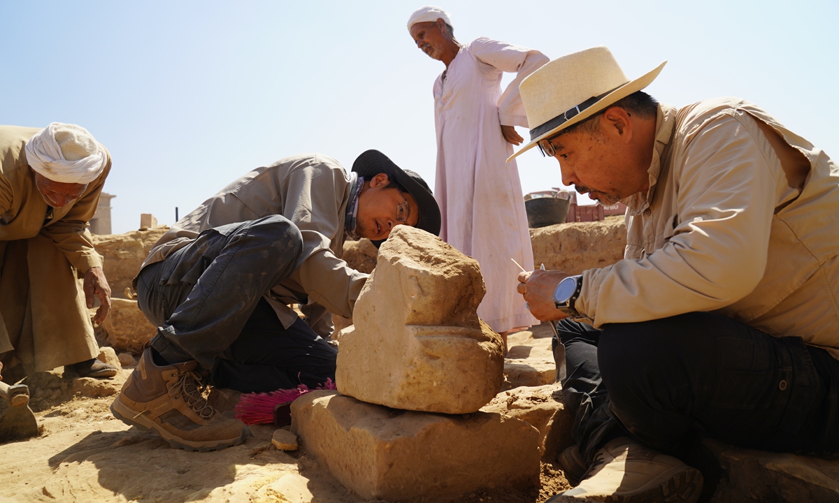 Archaeological teams from China and Egypt clean statues at the site of the Montu Temple in Egypt. Photo: Courtesy of National Cultural Heritage Administration