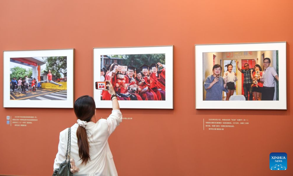 A woman visits a photo exhibition focused on the achievements of China's urban construction in Beijing, capital of China, Sept. 23, 2026. The exhibition displays nearly 200 photographs taken by Xinhua photographers, offering a visual narrative of China's urban construction. (Xinhua/Li Xulun)