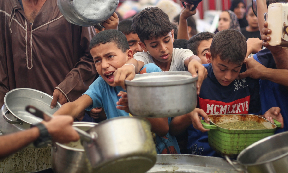 Displaced Palestinians receive hot meals distributed by a charity kitchen in the Nuseirat camp for Palestinian refugees, central Gaza Strip on October 7, 2026. Israel carried out new strikes in Gaza on October 7 as it marked the third anniversary of the October 7, 2023 attacks by Hamas, with Palestinian officials reporting two dead, according to media reports. Photo: VCG