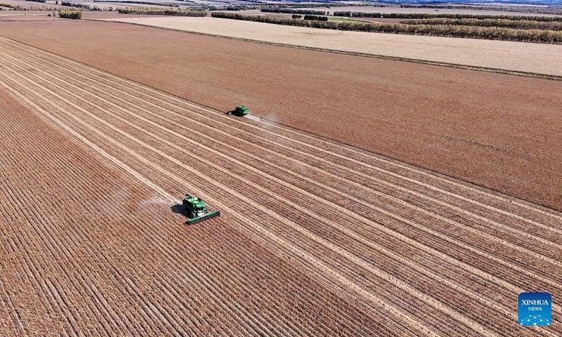 An aerial drone photo taken on Sept. 23, 2026 shows harvesters working in a soybean field of a farm under Beidahuang Group in northeast China's Heilongjiang Province. (Photo by Lu Wenxiang/Xinhua)