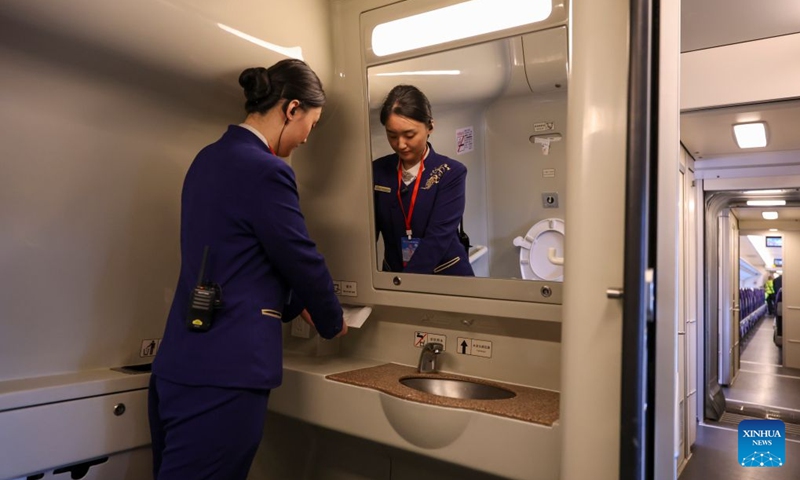 A crew member arranges tissues on a trial Electric Multiple Unit (EMU) train running along the Harbin-Yichun high-speed railway in northeast China's Heilongjiang Province, Sept. 22, 2026. As the Harbin-Yichun high-speed railway, China's northernmost high-speed railway, enters the final countdown to opening, workers are carrying out intensive training, emergency drills, equipment inspections and surveying to ensure its safe operation.
With a designed speed of 250 kilometers per hour, the 318-km line will slash travel time between Harbin and Yichun from about seven hours to just two hours once it becomes operational. Photo: Xinhua