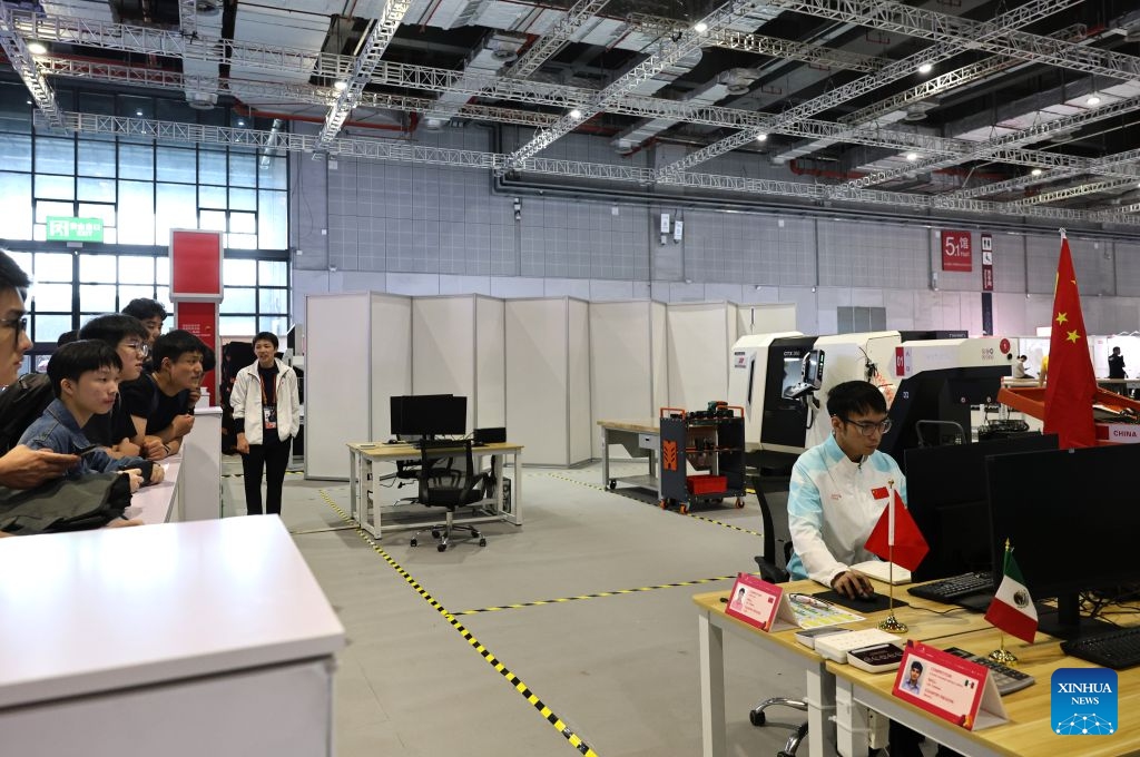 Visitors watch Chinese contestant Liao Junjie participating in the CNC turning event during the 48th WorldSkills Competition in east China's Shanghai, Sept. 24, 2026. The 48th WorldSkills Competition, currently being held at the National Exhibition and Convention Center (Shanghai), has attracted a large number of visitors. (Xinhua/Fang Zhe)