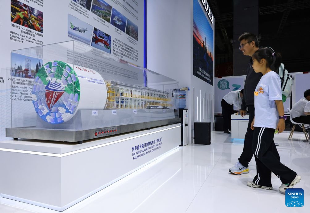 Visitors look at a model of the high-speed-rail shield tunneling machine Linghang, which was independently designed and manufactured in China, on display during the 48th WorldSkills Competition in east China's Shanghai, Sept. 24, 2026. The 48th WorldSkills Competition, currently being held at the National Exhibition and Convention Center (Shanghai), has attracted a large number of visitors. (Xinhua/Fang Zhe)