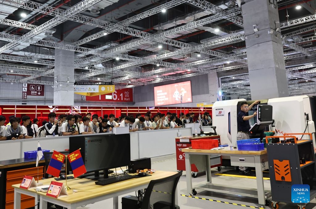 A group of vocational school students watch a contestant participating in the CNC milling event during the 48th WorldSkills Competition in east China's Shanghai, Sept. 24, 2026. The 48th WorldSkills Competition, currently being held at the National Exhibition and Convention Center (Shanghai), has attracted a large number of visitors. (Xinhua/Fang Zhe)