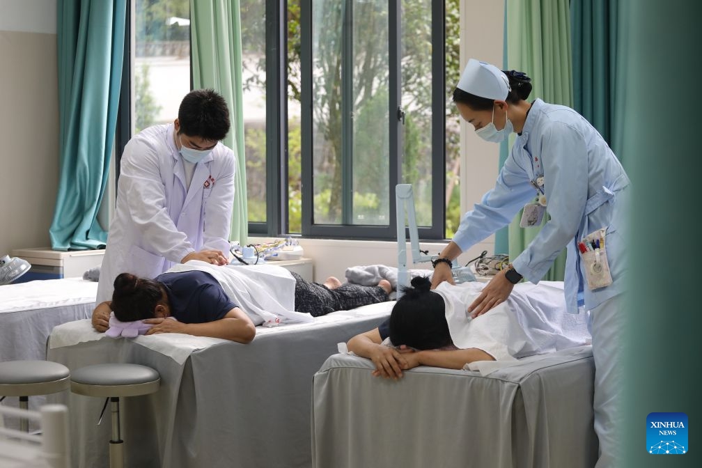 Medical staff members provide physiotherapy to people at a hot spring therapy center at a local hospital in Longling County of Baoshan City, southwest China's Yunnan Province, Sept. 22, 2026. In recent years, Baoshan has been developing wellness tourism around its abundant hot spring resources, attracting visitors from neighboring cities and other parts of China. (Photo by Yang Tingrong/Xinhua)
