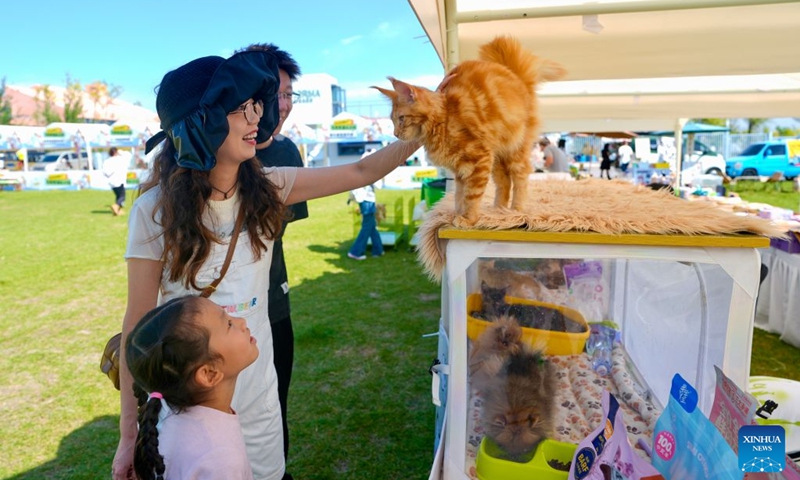 Citizens interact with a pet cat during a pet-themed event held in Yinchuan, northwest China's Ningxia Hui Autonomous Region, Sept. 26, 2026. A pet-themed event was held here from Friday to Saturday. This event, aligning with emerging trends favored by young people, features pet competitions, trendy markets, and Mid-Autumn Festival cultural experiences. (Xinhua/Yang Zhisen)