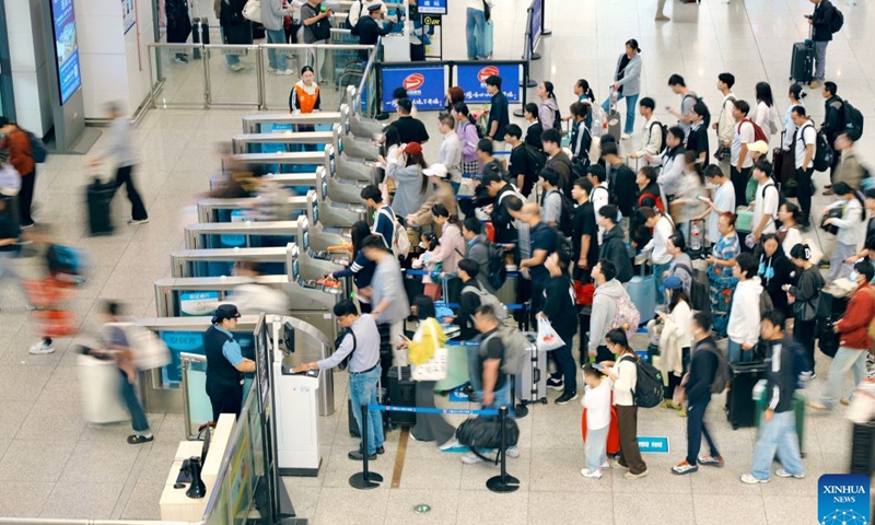 Passengers head to board the train at Xuzhou East Railway Station in Xuzhou City, east China's Jiangsu Province, Sept. 25, 2026. A travel rush is observed across China as the country celebrates the Mid-Autumn Festival, which falls on Friday this year. (Photo by Zhang Guanglei/Xinhua)