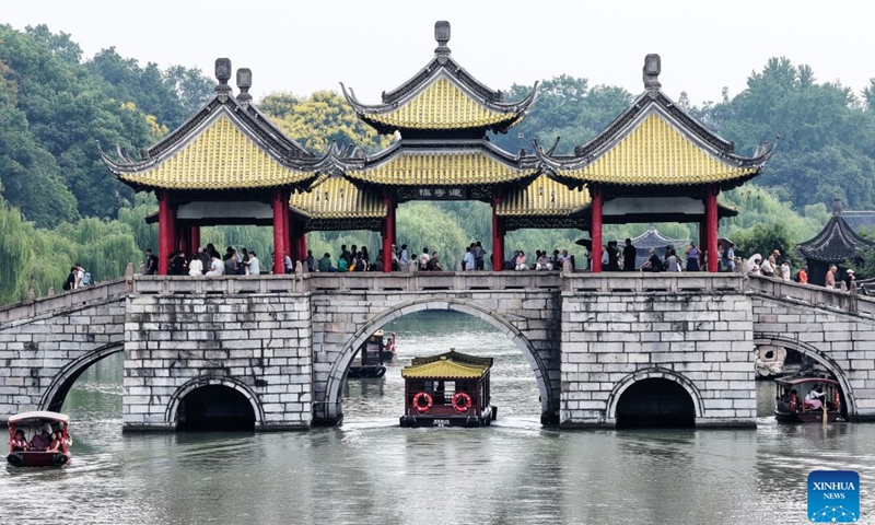 A drone photo taken on Sept. 25, 2026 shows tourists visiting the Slender West Lake scenic spot in Yangzhou, east China's Jiangsu Province. Friday marks this year's Mid-Autumn Festival. It is celebrated annually on the 15th day of the eighth month in the Chinese traditional calendar. Diverse events were held on Friday across China to celebrate the festival. (Photo by Meng Delong/Xinhua)