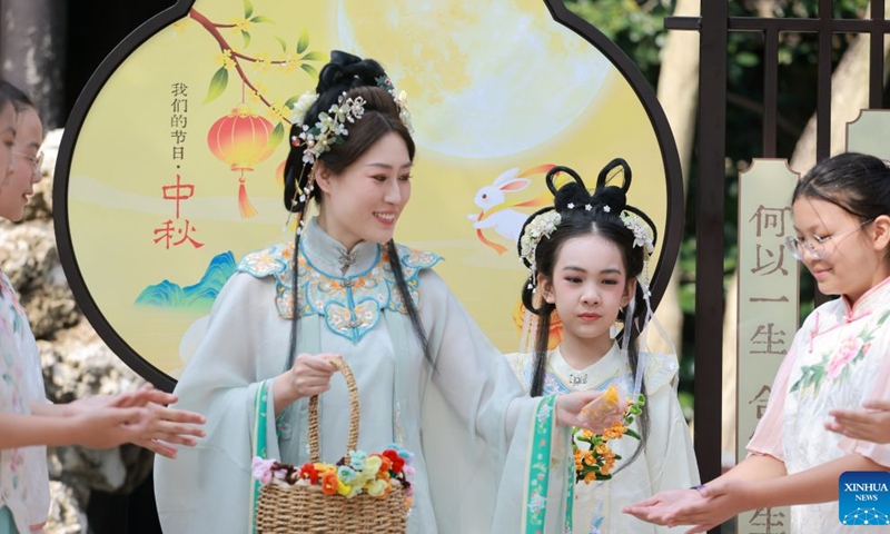 A staff member distributes moon cakes to tourists at a scenic area in Yangzhou, east China's Jiangsu Province, Sept. 25, 2026. Friday marks this year's Mid-Autumn Festival. It is celebrated annually on the 15th day of the eighth month in the Chinese traditional calendar. Diverse events were held on Friday across China to celebrate the festival. (Photo by Meng Delong/Xinhua)