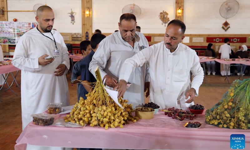 People check dates displayed at an annual date festival in Salahuddin Province, Iraq, on Sept. 25, 2026. (Xinhua/Khalil Dawood)