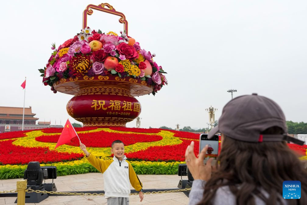 A boy poses for photos with a giant floral basket installation at Tian'anmen Square in Beijing, capital of China, Sept. 25, 2026.
A giant floral basket has been installed on Tian'anmen Square for the upcoming National Day holiday. Ten sets of three-dimensional flower beds will be arranged along Chang'an Avenue to enhance the festive atmosphere during the holiday.
The green spaces on both sides of Tian'anmen Square continue to feature floral ribbons. Additionally, over 7,000 square meters of flowers will be placed along Chang'an Avenue. Photo: Xinhua