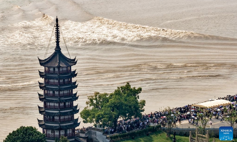 A drone photo taken on Sept. 25, 2026 shows people viewing the tidal bore of the Qiantang River at a park in Haining City, east China's Zhejiang Province. The Mid-Autumn Festival falls on Sept. 25 this year. Tourists came to the Yanguan section of the Qiantang River, the best tide-watching resort, to watch the tide during the best tide-viewing period. (Photo by Wang Zhenyu/Xinhua)