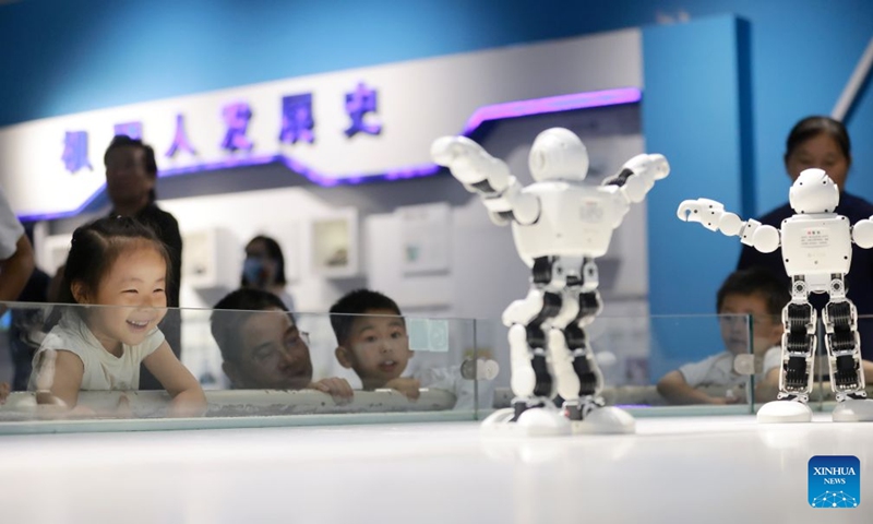 Children watch robots dancing at the Yangzhou Science and Technology Museum in Yangzhou, east China's Jiangsu Province, Sept. 26, 2026. Chinese people are on a three-day holiday for the Mid-Autumn Festival, which fell on Sept. 25 this year. (Photo by Meng Delong/Xinhua)