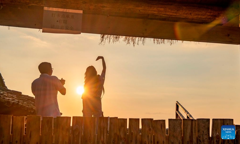 Tourists enjoy the sunrise views at Basha Village in Congjiang County of Qiandongnan Miao and Dong Autonomous Prefecture, southwest China's Guizhou Province, Sept. 26, 2026. (Photo by Wu Dejun/Xinhua)