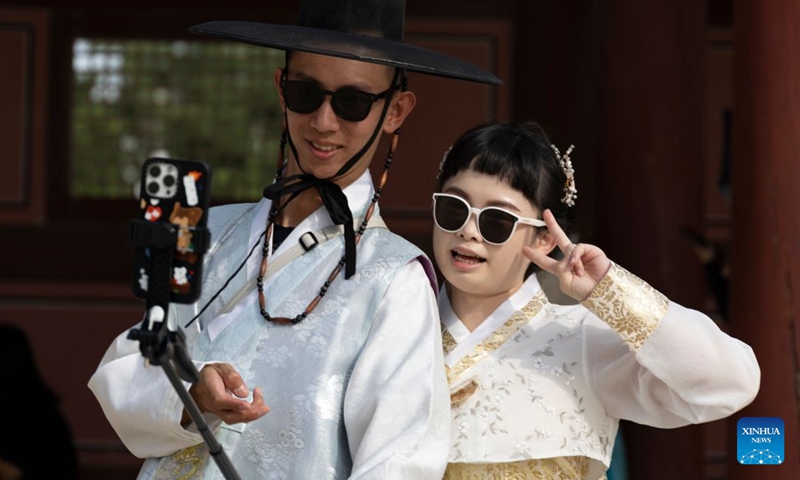 People wearing traditional Hanbok pose for selfies during the Chuseok holiday at the Gyeongbokgung Palace in Seoul, South Korea, Sept. 26, 2026. (Photo by Jun Hyosang/Xinhua)