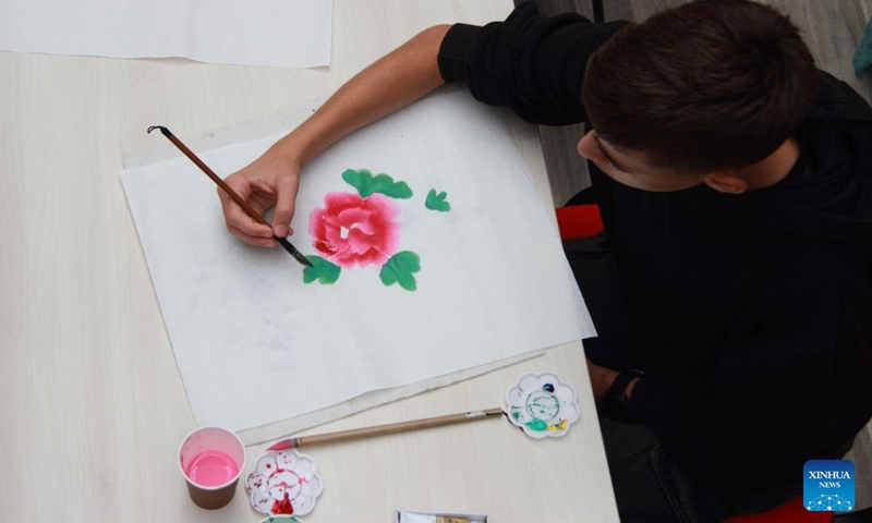 A boy paints a peony during an Open Day event hosted by the Confucius Institute in Sofia, Bulgaria, Sept. 26, 2026. The Confucius Institute in Sofia held art workshops during an Open Day event on Saturday. (Photo by Marian Draganov/Xinhua)
