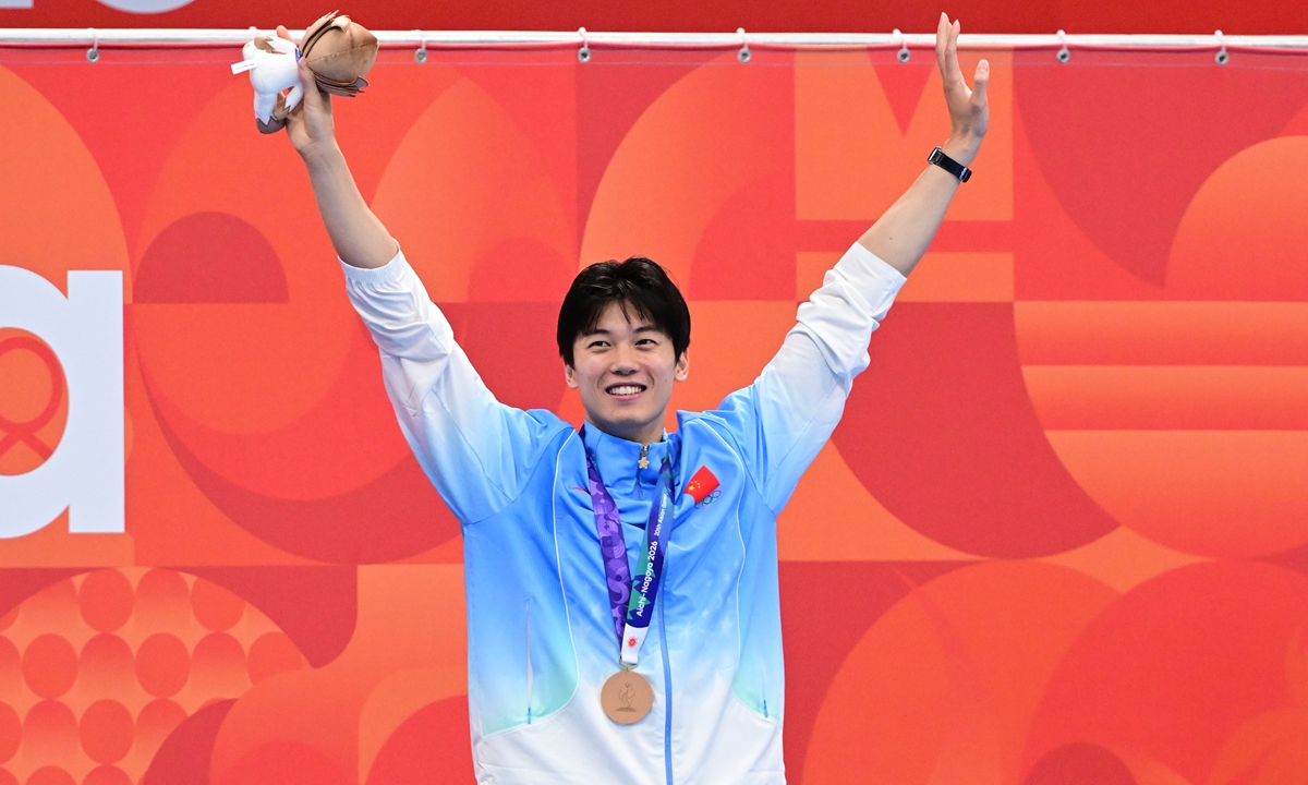 Wang Shun waves to spectators during the medal ceremony at the 2026 Aichi-Nagoya Asian Games on September 22, 2026. 
