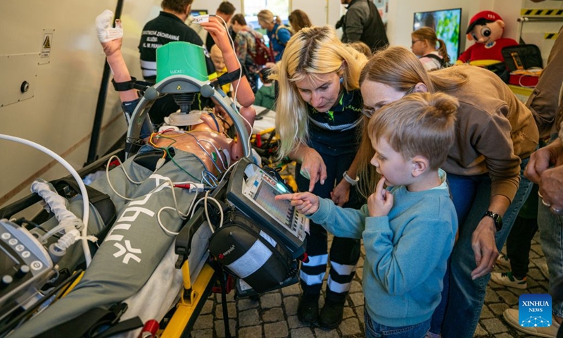 A child explores emergency medical equipment during the Heroes' Day event in Prague, the Czech Republic, Sept. 26, 2026. The event was held in Prague on Saturday, bringing together firefighters, police officers, emergency medical personnel and representatives of other rescue, security and organizations. They showcased vehicles and equipment, demonstrated emergency response skills, and offered interactive activities to raise public preparedness for emergencies. (Photo by Dana Kesnerova/Xinhua)