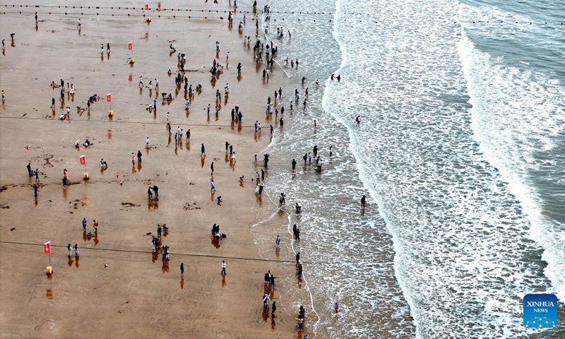 An aerial drone photo taken on Sept. 26, 2026 shows people enjoying leisure time on a beach in Lianyungang, east China's Jiangsu Province. Chinese people are on a three-day holiday for the Mid-Autumn Festival, which fell on Sept. 25 this year. (Photo by Wang Chun/Xinhua)