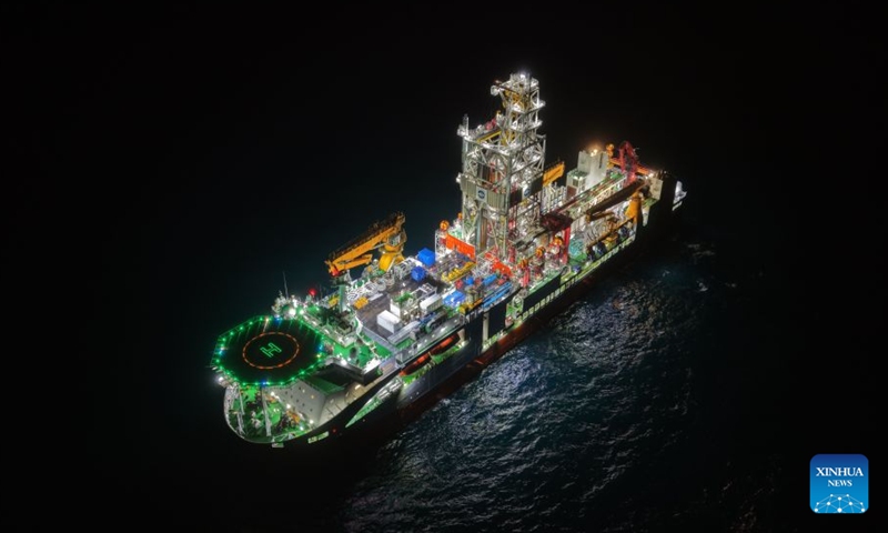 An aerial drone photo taken on July 28, 2026 shows China's ocean drilling vessel Mengxiang conducting an operation at night. China's Mengxiang ocean drilling vessel has set a national record for deep-sea drilling, elevating its capability to the 5,000-meter level, after obtaining basalt samples from the South China Sea basin, the Ministry of Natural Resources said on Monday. This marks China's entry into international advanced ranks in deep-sea drilling operation capacity, according to the ministry. (Photo by Zhang Fatao/Xinhua)