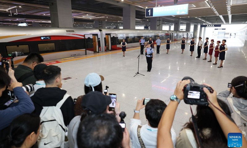 Train attendants are seen beside G9997, the first train of the Xi'an-Ankang high-speed railway, at Xi'an East Railway Station in Xi'an, northwest China's Shaanxi Province, Sept. 28, 2026. The Xi'an-Ankang high-speed railway was officially put into operation on Monday, cutting the railway travel time between Xi'an and Ankang to less than one hour. Spanning about 171 kilometers and with a design speed of 350 kilometers per hour, the railway runs through the cities of Xi'an, Shangluo and Ankang in Shaanxi Province and has five stations along the line. (Xinhua/Li Yibo)