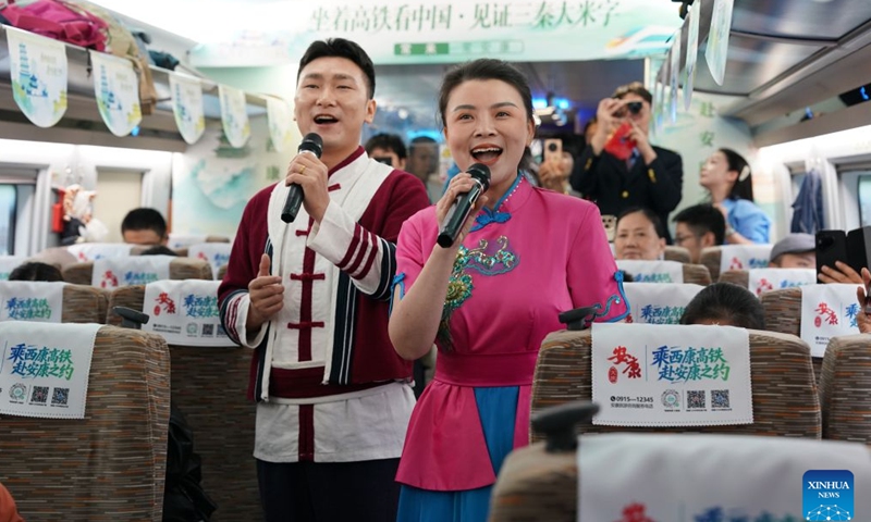 Singers from Ankang City perform on G9997, the first train of the Xi'an-Ankang high-speed railway, in northwest China's Shaanxi Province, Sept. 28, 2026. The Xi'an-Ankang high-speed railway was officially put into operation on Monday, cutting the railway travel time between Xi'an and Ankang to less than one hour. Spanning about 171 kilometers and with a design speed of 350 kilometers per hour, the railway runs through the cities of Xi'an, Shangluo and Ankang in Shaanxi Province and has five stations along the line. (Xinhua/Shao Rui)