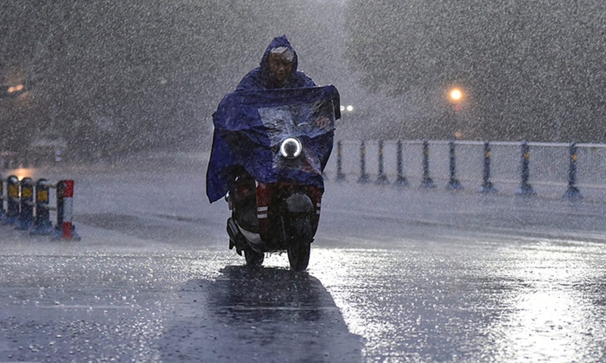 A resident in Fuyang, East China's Anhui Province, travels through heavy rain on August 30, 2026. The city experienced severe rainfall that day under the influence of the remnants of Typhoon Saudel. Photo: VCG