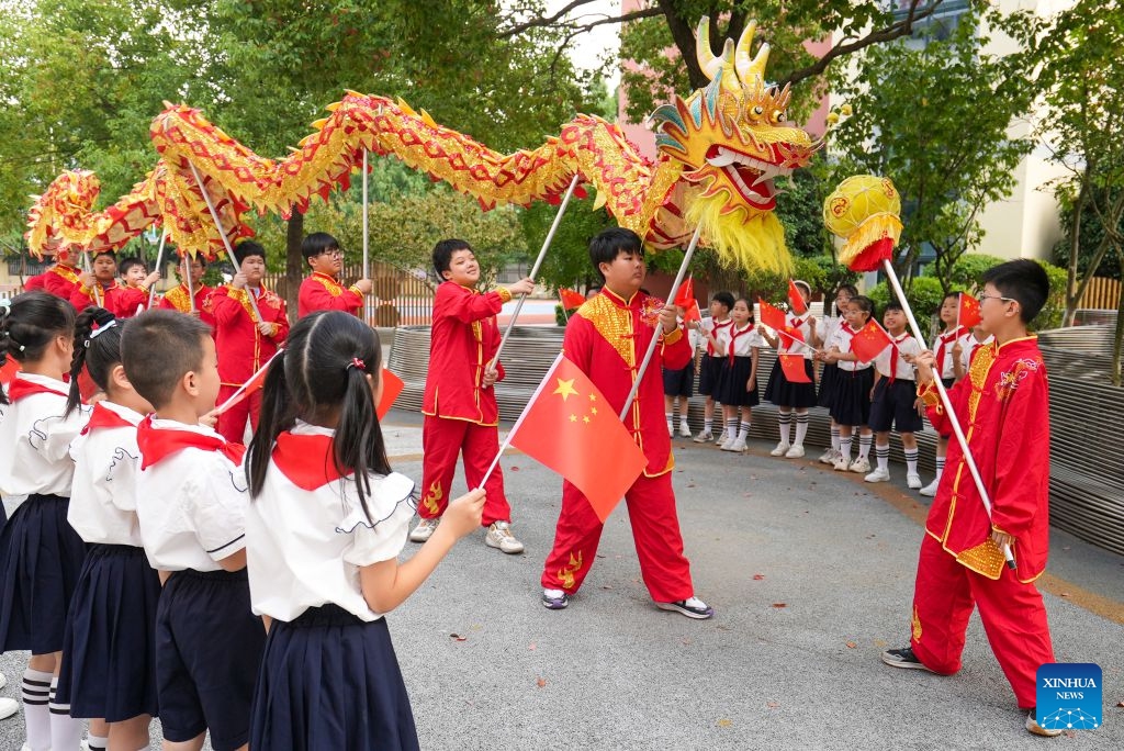 Students watch a dragon-dance performance in Xinghua City, east China's Jiangsu Province, Sept. 29, 2026. Various events are held across China in celebration of the upcoming National Day. (Photo: Xinhua)