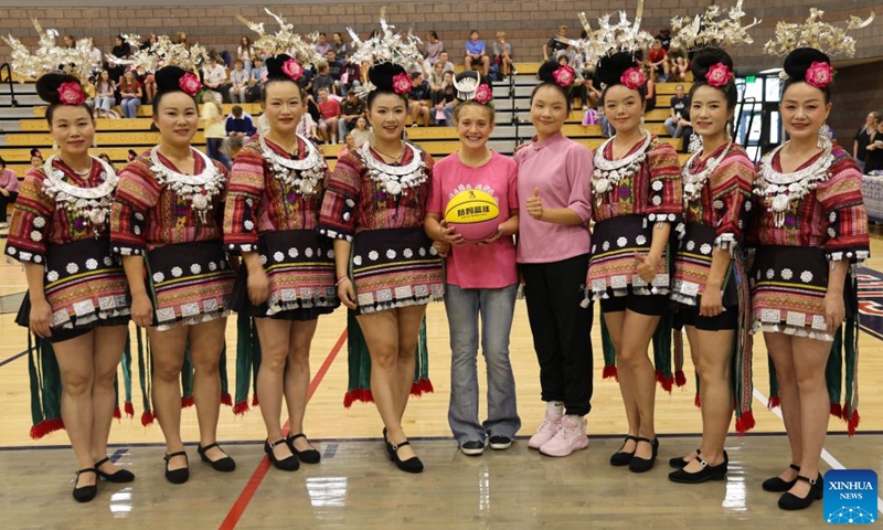 Members of Auntie Basketball pose for a group photo with an American student at Crimson Cliffs High School in Washington, Utah, the United States, Oct. 2, 2026.(Photo by Zeng Hui/Xinhua)