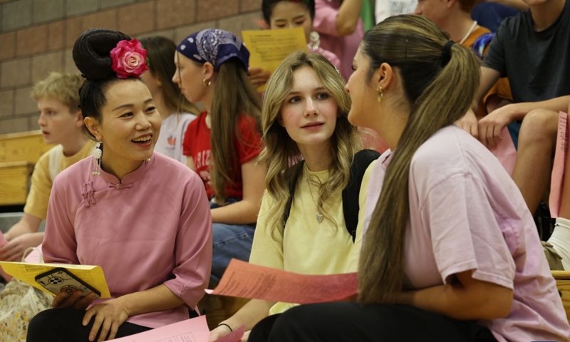 A member of Auntie Basketball talks with American students at Crimson Cliffs High School in Washington, Utah, the United States, Oct. 2, 2026.(Photo by Zeng Hui/Xinhua)