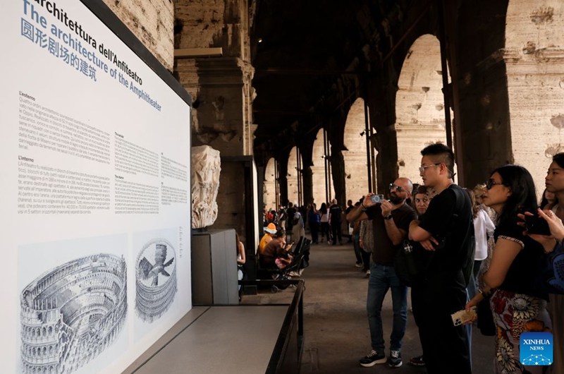 Tourists look at an exhibition panel in the Colosseum in Rome, Italy, Oct. 4, 2026. (Xinhua/Li Jing)