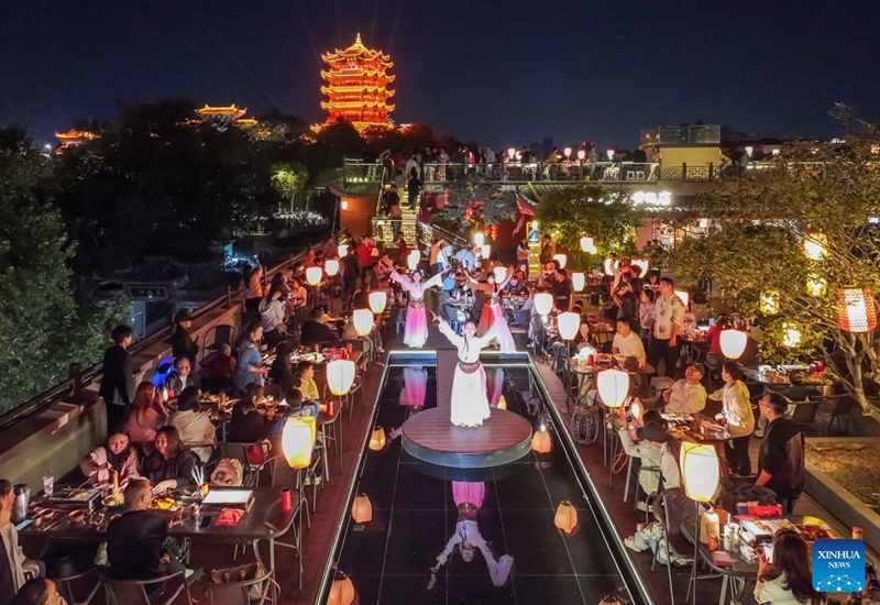A drone photo taken on Oct. 5, 2026 shows people watching a performance with the Yellow Crane Tower in the background in Wuhan, central China's Hubei Province. During the National Day holiday, night tours were launched across China to create diversified consumption scenes. Photo: Xinhua
