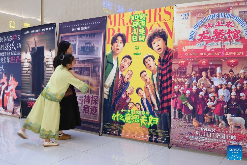 Spectators look at posters at a cinema in Hai'an City, east China's Jiangsu Province, Oct. 6, 2026. During the National Day holiday, people go to cinemas to watch movies across China. (Photo by Xu Jingbo/Xinhua)