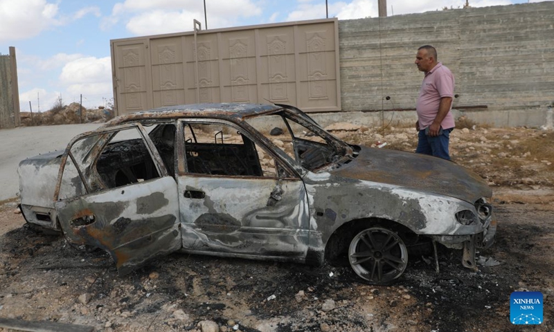 A Palestinian man inspects a vehicle burnt by Israeli settlers in the town of al-Samu, south of Hebron in the West Bank, Oct. 6, 2026. Photo: Xinhua