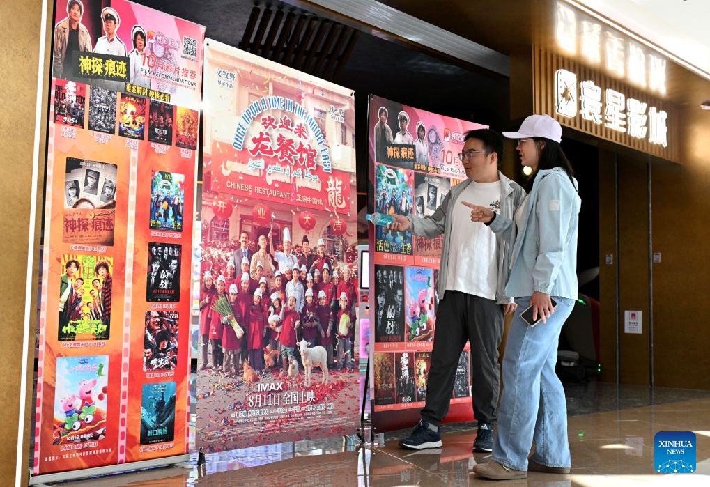 Spectators look at posters at a cinema in Shijiazhuang City, north China's Hebei Province, Oct. 6, 2026. During the National Day holiday, people go to cinemas to watch movies across China. (Photo by Chen Qibao/Xinhua)