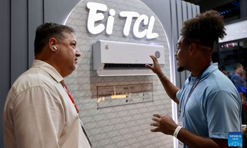 A staff member (R) introduces an air conditioner of TCL during the FEBRAVA Rio at the Riocentro convention and event center in Rio de Janeiro, Brazil, Oct. 6, 2026. The three-day FEBRAVA Rio (Portuguese short for International Fair of Refrigeration, Air Conditioning, Ventilation, Heating, Air and Water Treatment) kicked off here on Tuesday. Some Chinese brands showcased their latest products during the fair, drawing great attention from visitors. Photo: Xinhua
