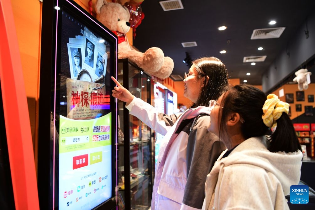 Spectators check information at a cinema in Suihua, northeast China's Heilongjiang Province, Oct. 6, 2026. During the National Day holiday, people go to cinemas to watch movies across China. (Photo by Liu Huapeng/Xinhua)