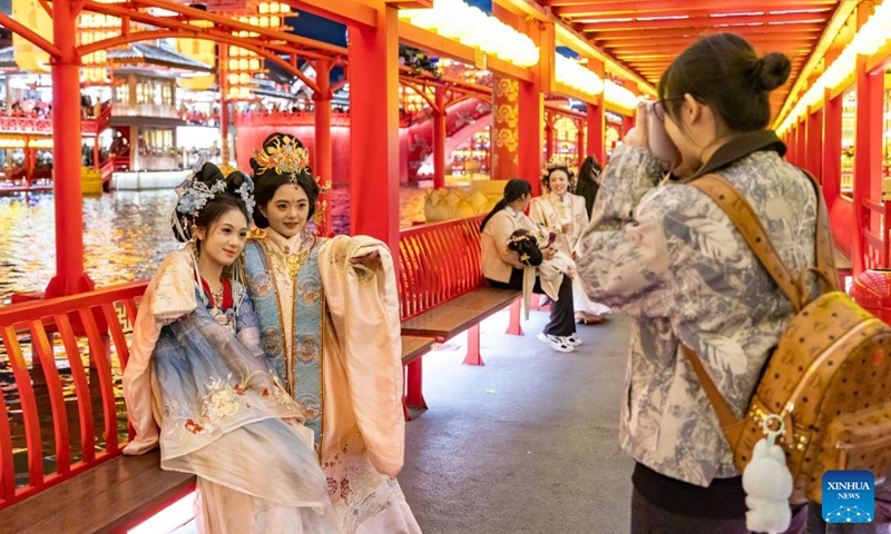 Tourists pose for a photo at the Hetou Old Street scenic area in Fengnan District of Tangshan City, north China's Hebei Province, Oct. 3, 2026. During the National Day holiday, night tours were launched across China to create diversified consumption scenes. Photo: Xinhua